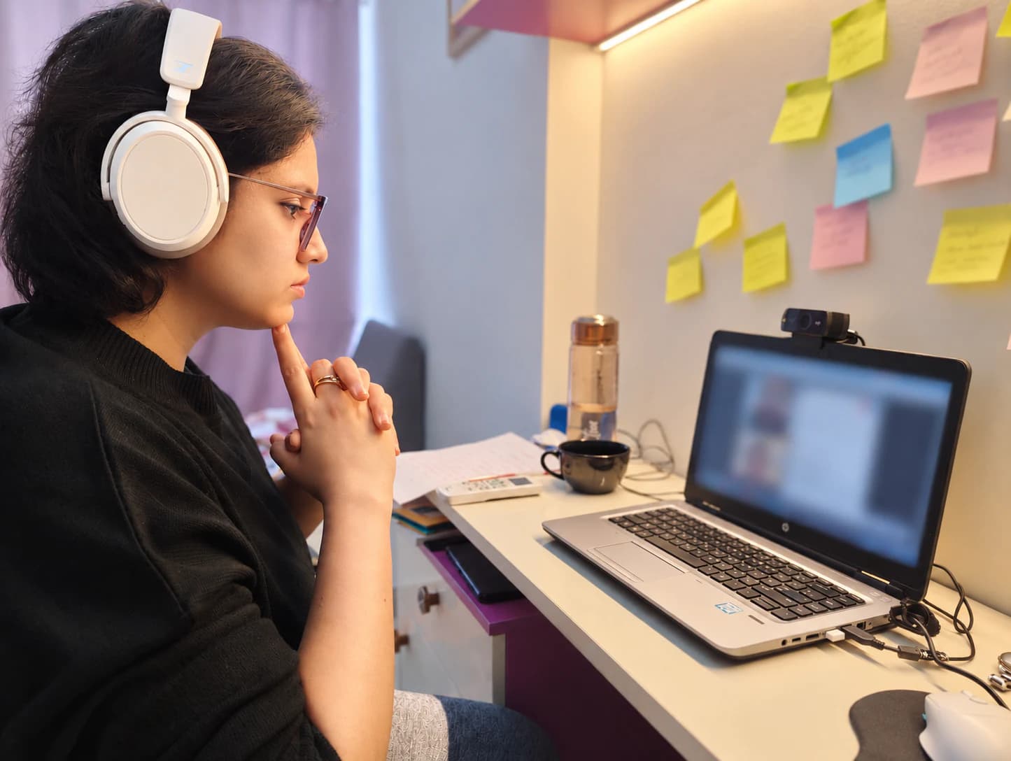 Priya wearing headphones while working at a desk